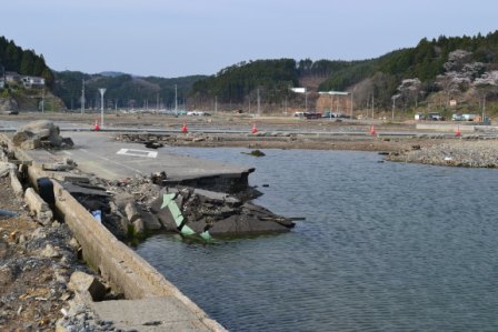 道路が崩壊し崩れた部分が水溜りに浸かっている写真