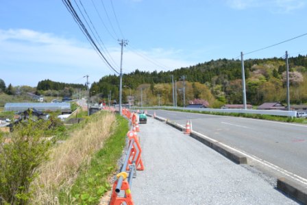 工事中の道路の端に赤のフェンスが一列に続いている写真