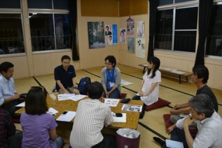 有志の方々が机を囲んですわっており、資料を机に広げて話をしている様子の写真