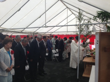 神主が祝詞を奏上する中、関係者や地域住民が一列に並んで頭を下げている、清水トンネル工事の無事を祈る神事の写真