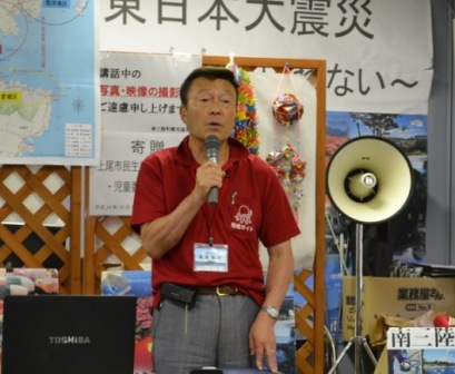 マイクをもって話をしている鴻巣修治さんの写真