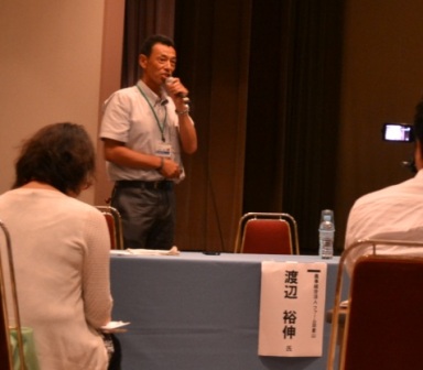 渡辺裕伸さんがマイクをもって話をしている様子の写真