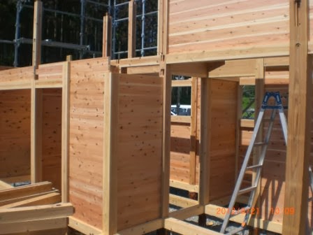 柱と梁の構造がしっかりと組まれた建設中の木造施設の一部を、壁の木目や接合部がよく見える角度から撮影している写真