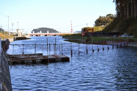 川を渡すように柵が設置され、左側には足場が設けられている鮭捕獲施設の写真