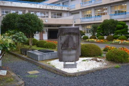 南三陸町の志津川高校の校舎前に植栽と並んで設置されている、頭部のみのモアイ像の写真