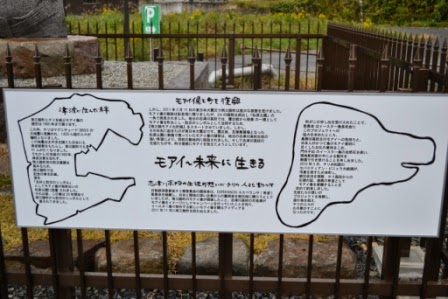 フェンスに取り付けられたモアイ像に関する案内看板の写真