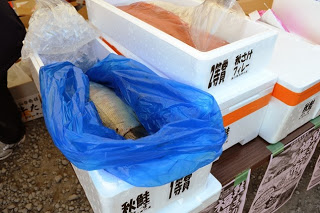 発泡スチロールの箱に入った丸ごとの生鮭や切り身が、保冷された状態で販売されている様子を写した写真