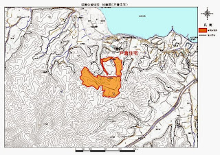 等高線と地形の詳細が描かれ、赤枠で囲まれたオレンジ色の区域が強調された建設予定地の戸倉住宅を示す地図