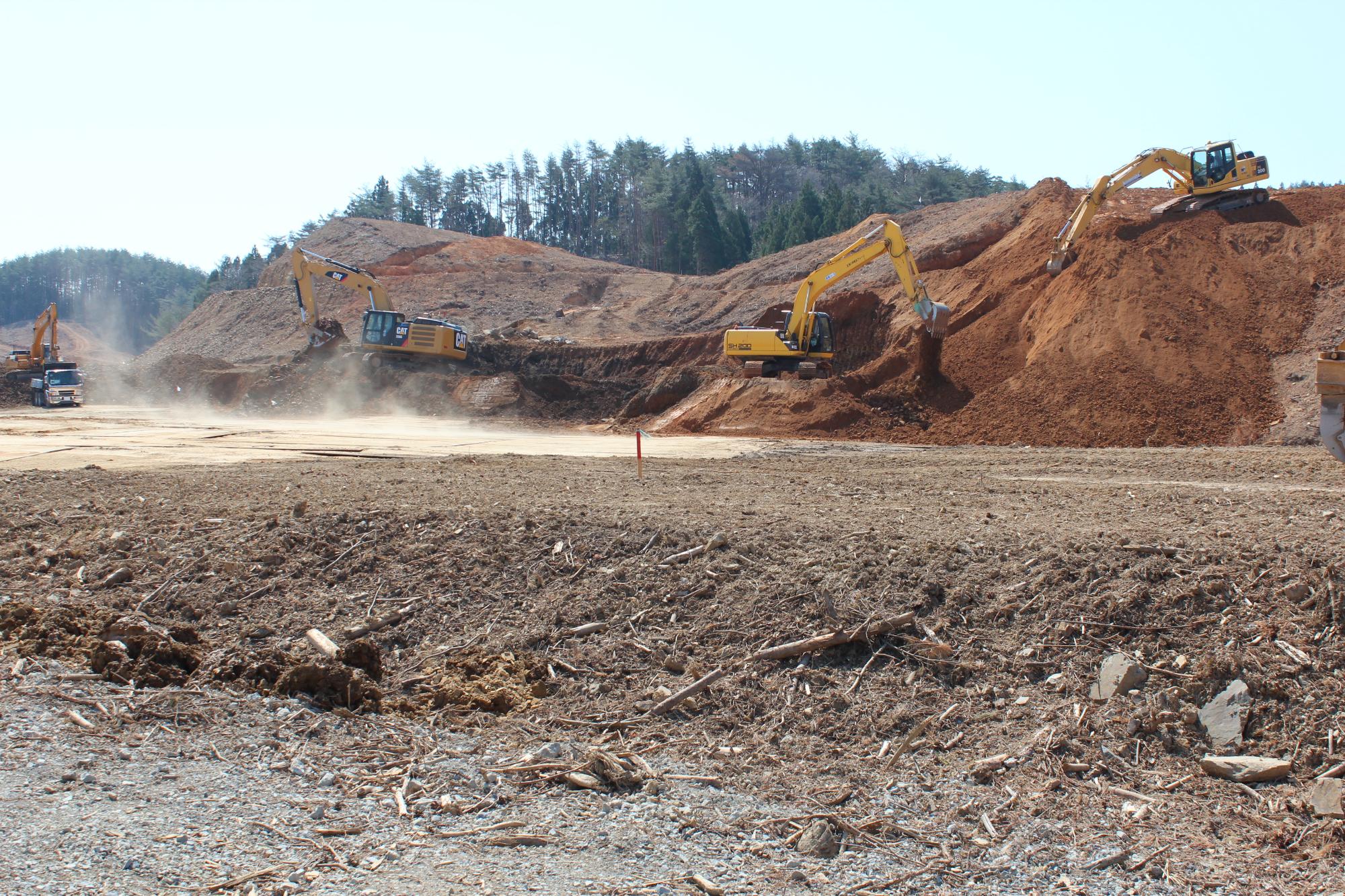 山の斜面を重機で削りながら造成工事が行われている様子を写した写真
