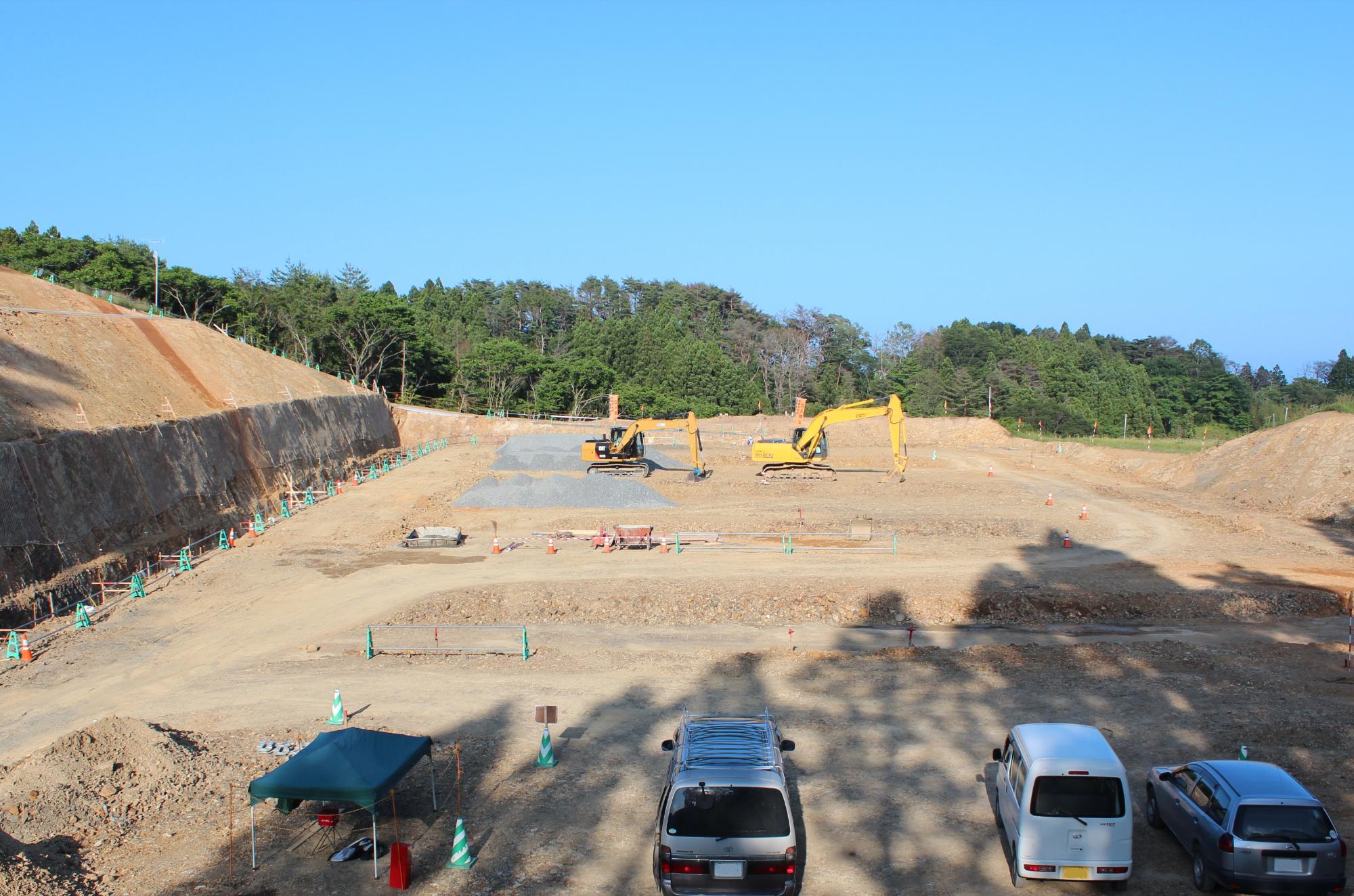 整地が進み、重機が複数台並び作業している晴天の建設現場の写真