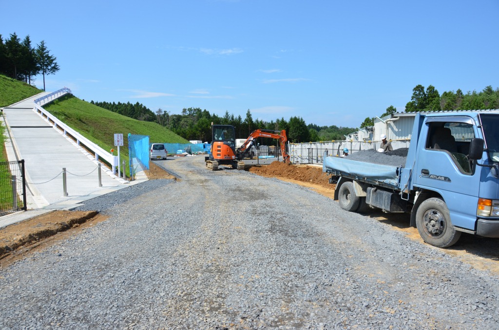 舗装工事中の道路で、トラックや重機が作業している工事現場の写真