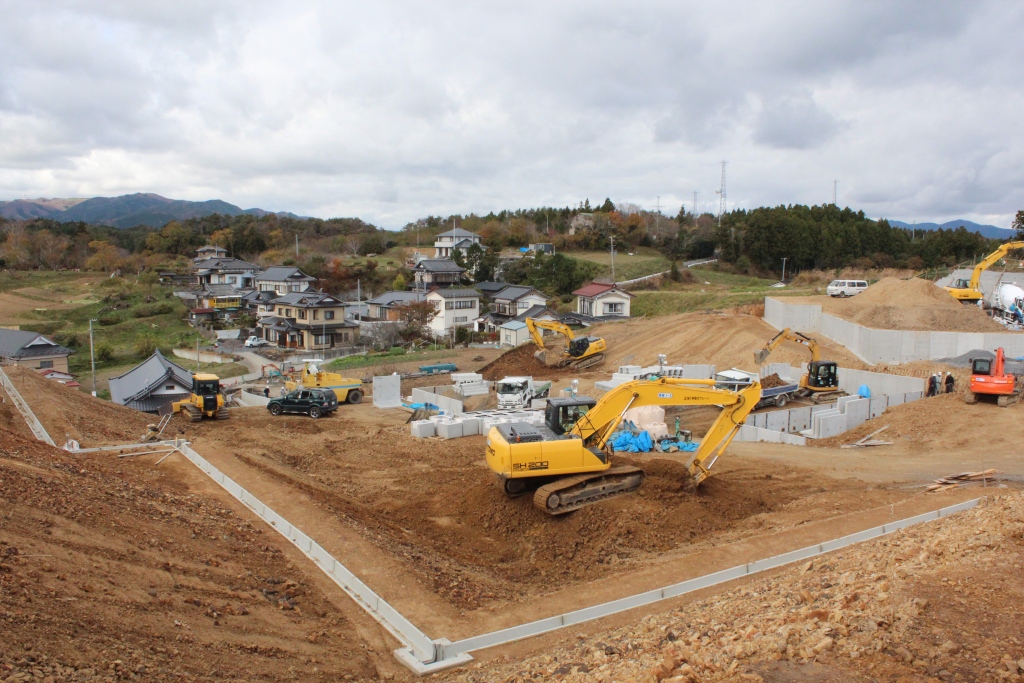 区画整理された整地済みの土地が階段状に広がり、沢山の重機が作業を行っている造成工事が完了間近の写真
