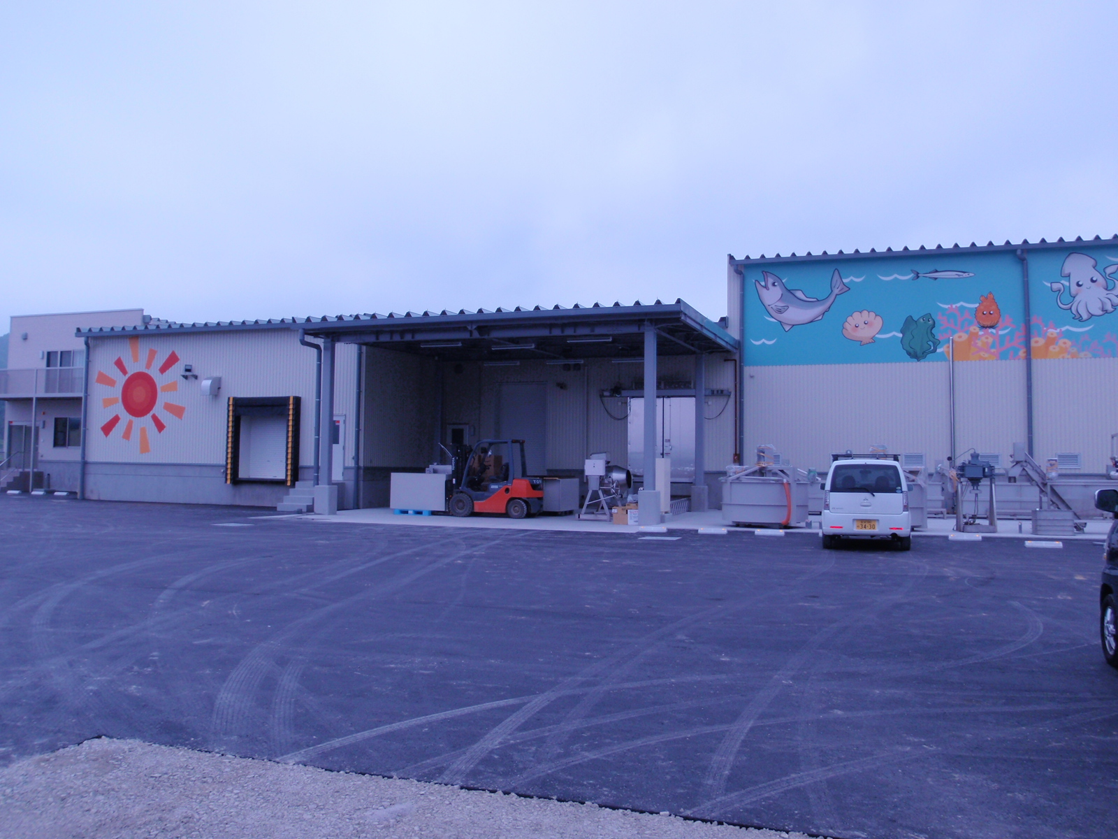 外壁に太陽や魚がイラストされた建物の外観写真