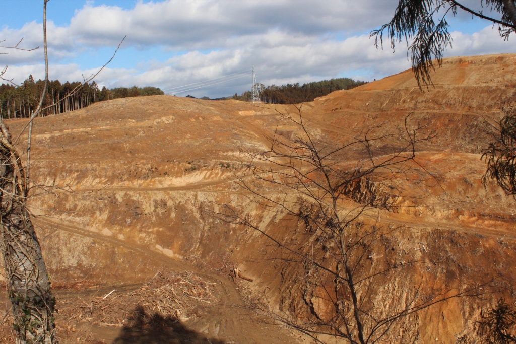 地面が削られ造成された山あいの広大な土地の写真