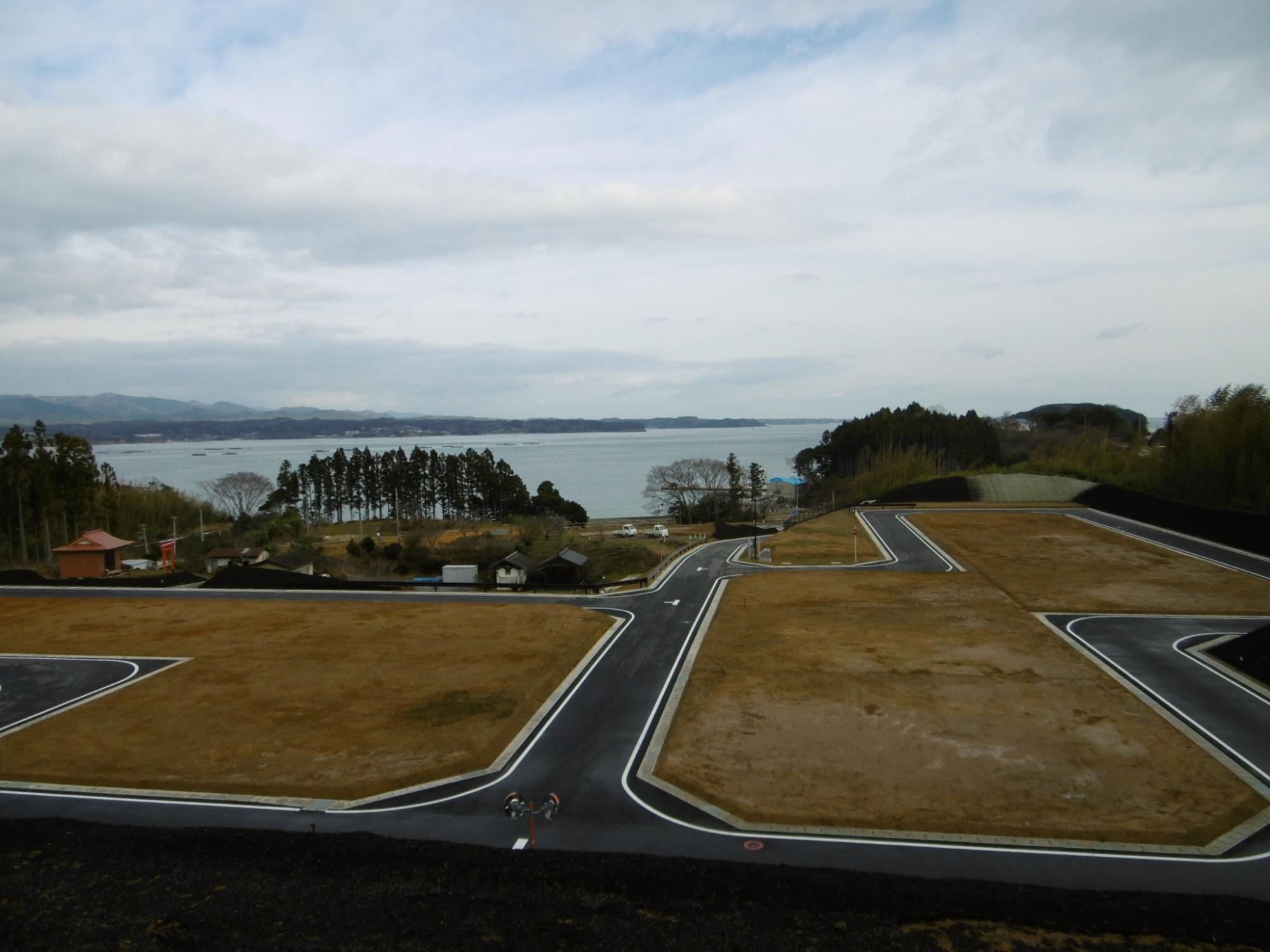 海に面した造成地に整備された道路と区画が広がっている写真
