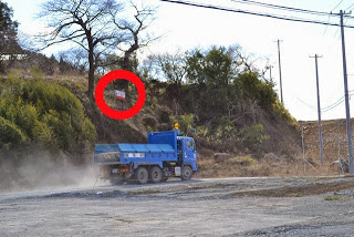 青いトラックの横の目印の看板を赤丸で囲われている写真