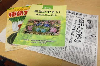 「春告げ野菜栽培マニュアル」「2015種苗ガイド」「日本農業新聞のコピー」の資料を机に並べて置いている写真
