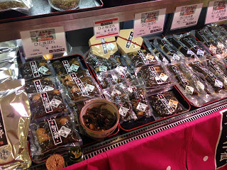 丸い器に試食品、周りに商品が並べられた商品棚を上から写した写真