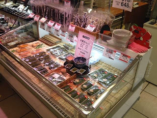 商品棚の中央にメカブの試食が置いてあり、周りに袋詰めされた商品が並べられている写真