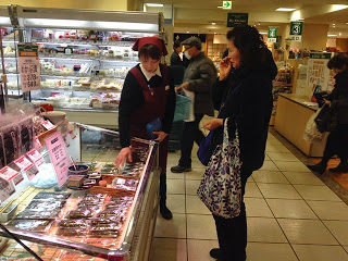 売り子の女性が女性のお客様に説明をしている様子を横から写した写真