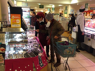 ショッピングカートの女性が、売り子の女性に商品の説明をうけている写真