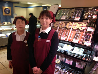 商品の前に並んでいる売り子の女性2名の写真