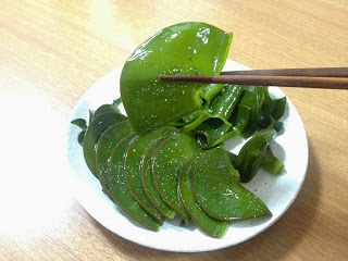 白い小皿に盛られためかぶを橋で持ち上げている写真