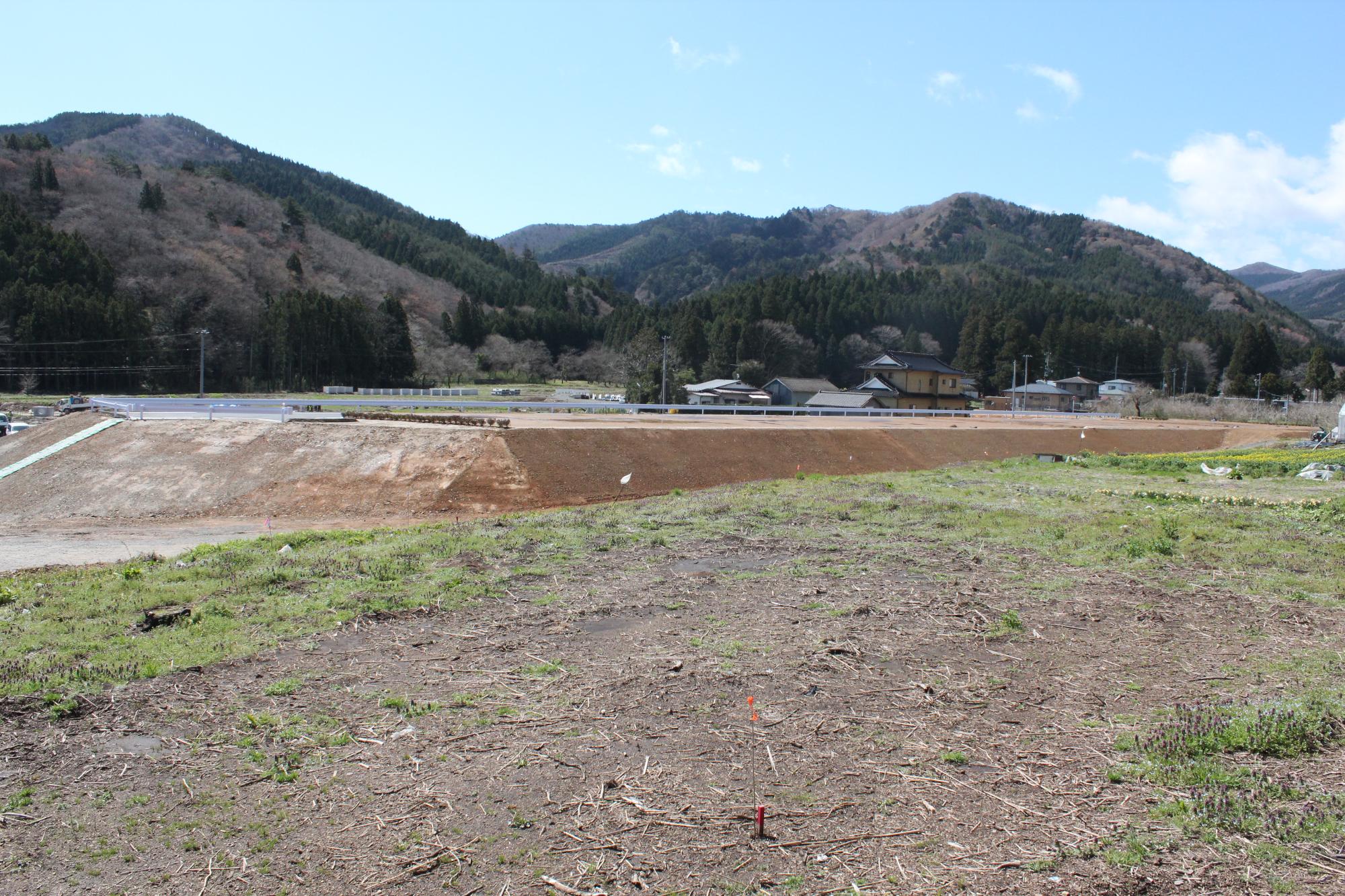 土を盛って整地された高台が広がり、高台の上は平らに整備され、白い柵が設置されている造成工事がほぼ完了した様子を写した写真