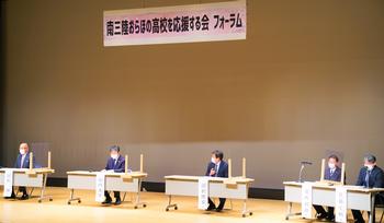 ステージ上で「南三陸おらほの高校を応援する会フォーラム」と書かれた横断幕の下、アクリル板で仕切られた机に着席したスーツ姿の5人がパネルディスカッションを行っている写真