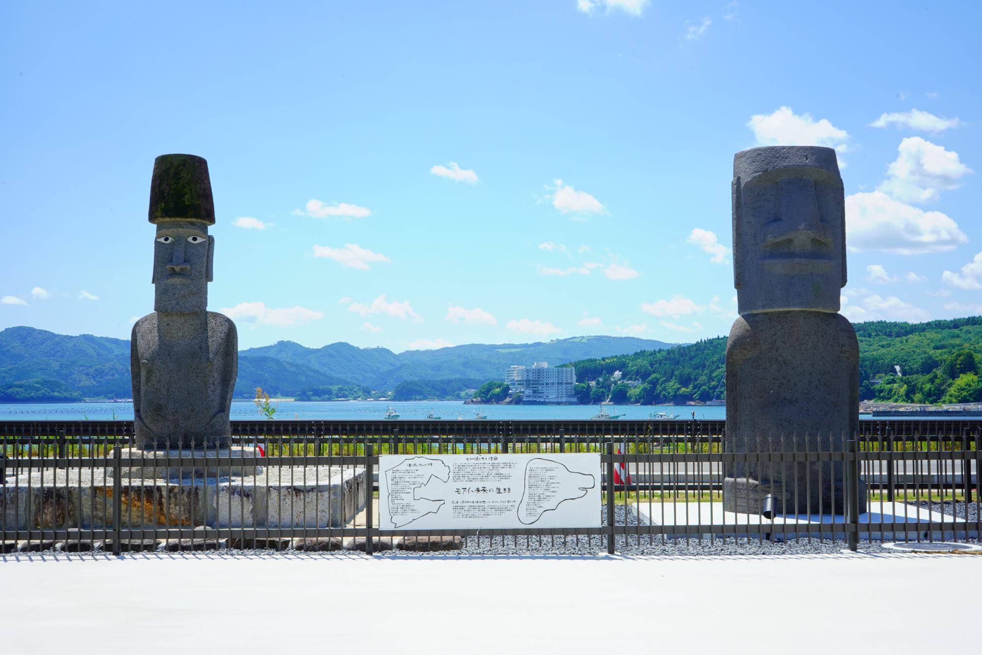 柵に囲まれた中にモアイ像が2体並んでいる写真