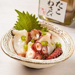 白い陶器の小鉢の中に、薄くスライスされたたこわさびが並べられてている写真