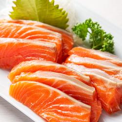 白い皿の上に、鮮やかなオレンジ色をしたサーモンの切り身が9つ、盛り付けられている写真