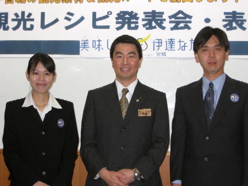 「観光レシピ発表会・表彰」という横断幕の前で、村井知事と表彰を受けたスーツ姿の鈴木さん、佐藤さんが並んで記念撮影行っている写真