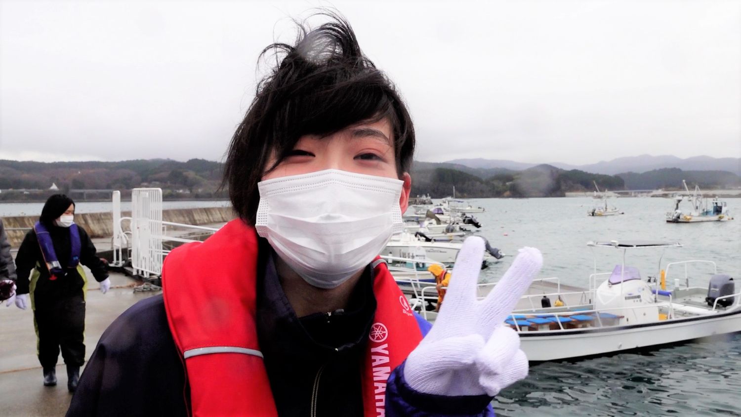 船着き場に戻ってきた女子生徒が、笑顔でピースサインをしてる写真