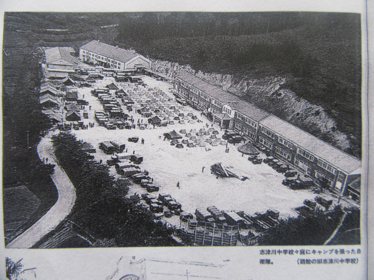 志津川中学校で開かれたキャンプの様子を上空から撮影しており、校庭に設営されたテントなどが写っている白黒写真