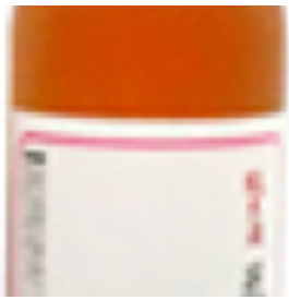 上半分がオレンジ色で、下に白とピンクのラベルがついた飲料ボトルの一部が写っている写真