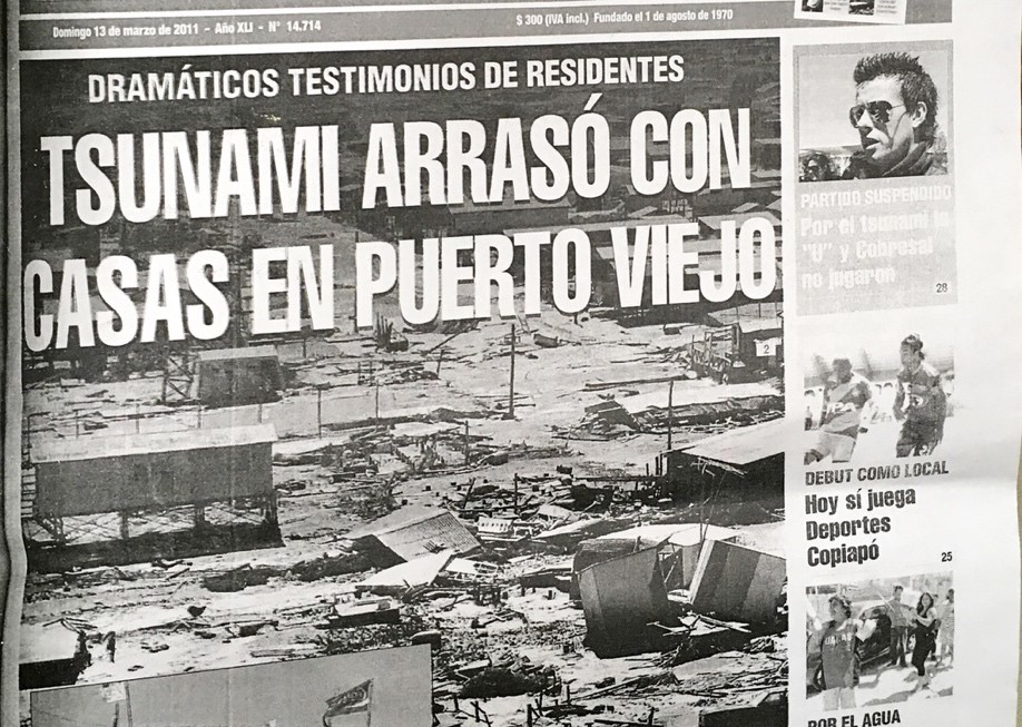 津波が家屋を破壊した被害の様子を写真を添えて伝えているチリの新聞の記事の写真