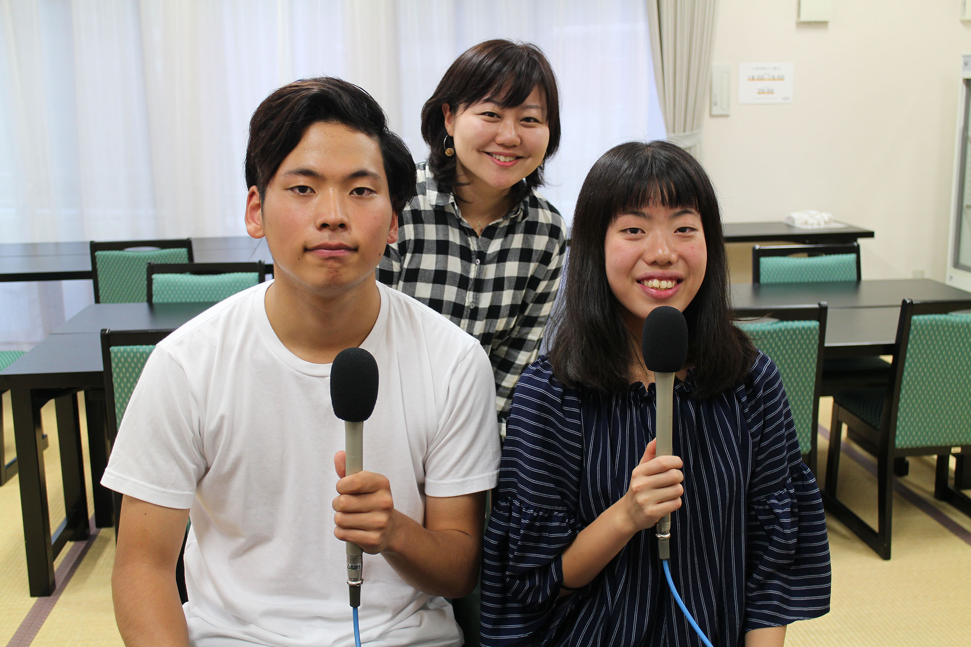 マイクを持った鈴木さん、小坂さんが手前に並び、その後ろに女性リポーターが入って写した記念写真