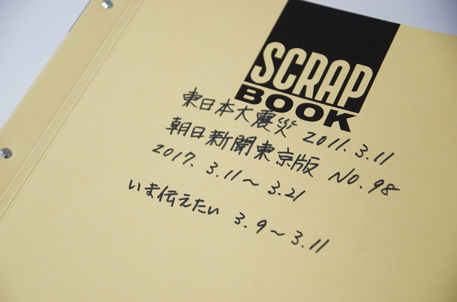 「東日本大震災 2011年3月11日 朝日新聞東京版 No.98 2017年3月11日～3月21日 いま伝えたい 3月9日～3月11日」と手書きで書かれたスクラップブックの表紙の写真