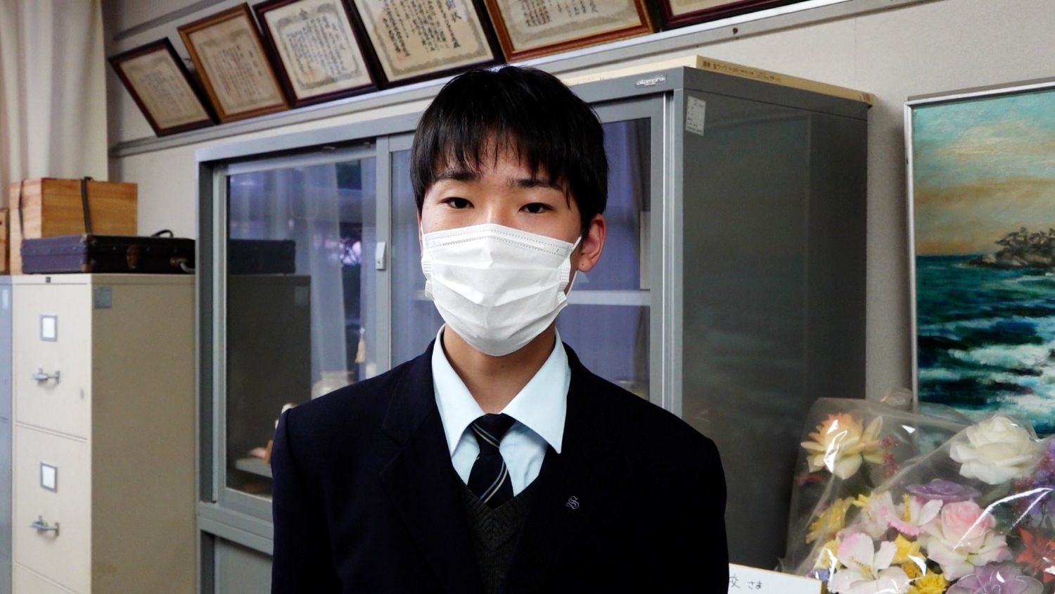 インタビューに答えたマスク姿の男子高校生の写真