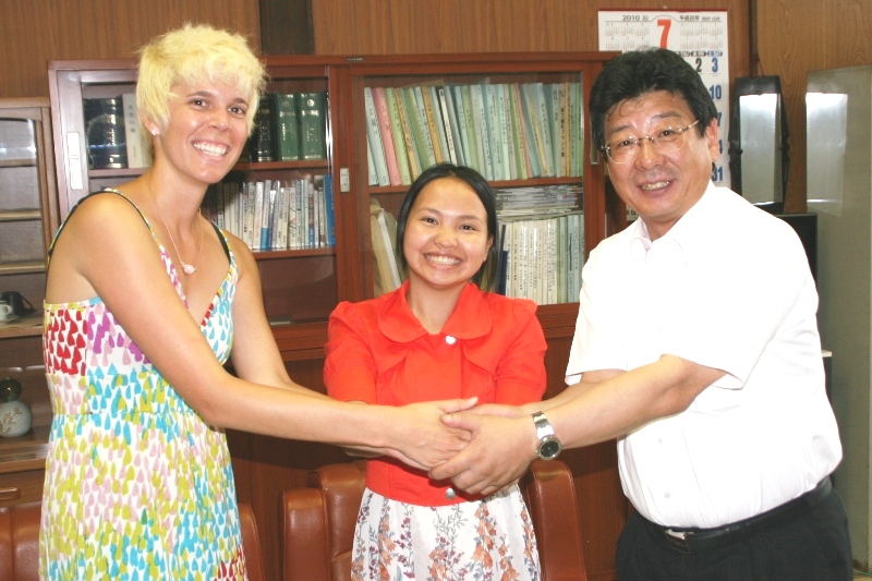 キャノン先生とリリアン先生、町長が笑顔で握手をし、カメラ目線で写っている写真