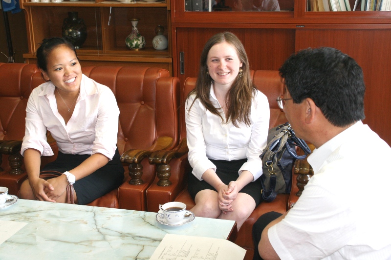 応接室で町長とALTの2人の女性が向かい合って座り、笑顔で着任のあいさつをしている様子の写真