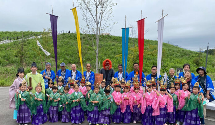 子どもたちが伝統的な色とりどりの和装を着て、大人たちと一緒に並んだ記念写真