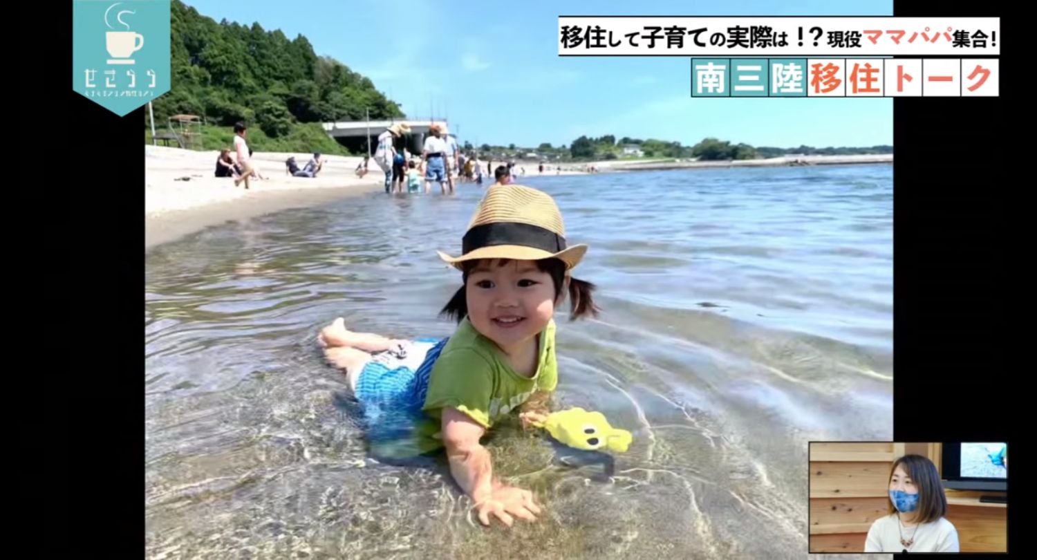 「移住して子育ての実際は！？現役ママパパ集合！南三陸移住トーク」のテーマタイトルが画面右上に表示されており、幼い女の子が麦わら帽子をかぶり、海の浅瀬で笑顔で寝そべって遊んでいる映像と右下のワイプ画像に女性が映っているYouTube LIVE配信番組のスクリーンショットの写真