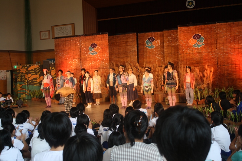 歌津中学校体育館で劇団四季の公演が行われており、生徒の皆さんが舞台を囲み、熱心に観劇している様子の写真