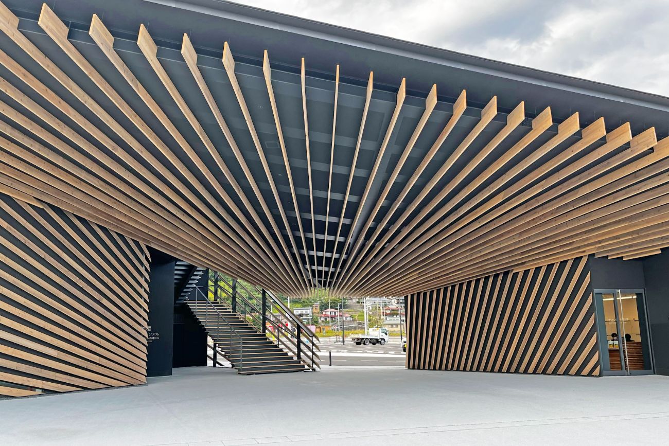 木製の格子状の天井装飾が美しく、建物の中央にある通路と階段を囲むように設計された、伝承館の特徴的な建築デザインの一部を写している写真