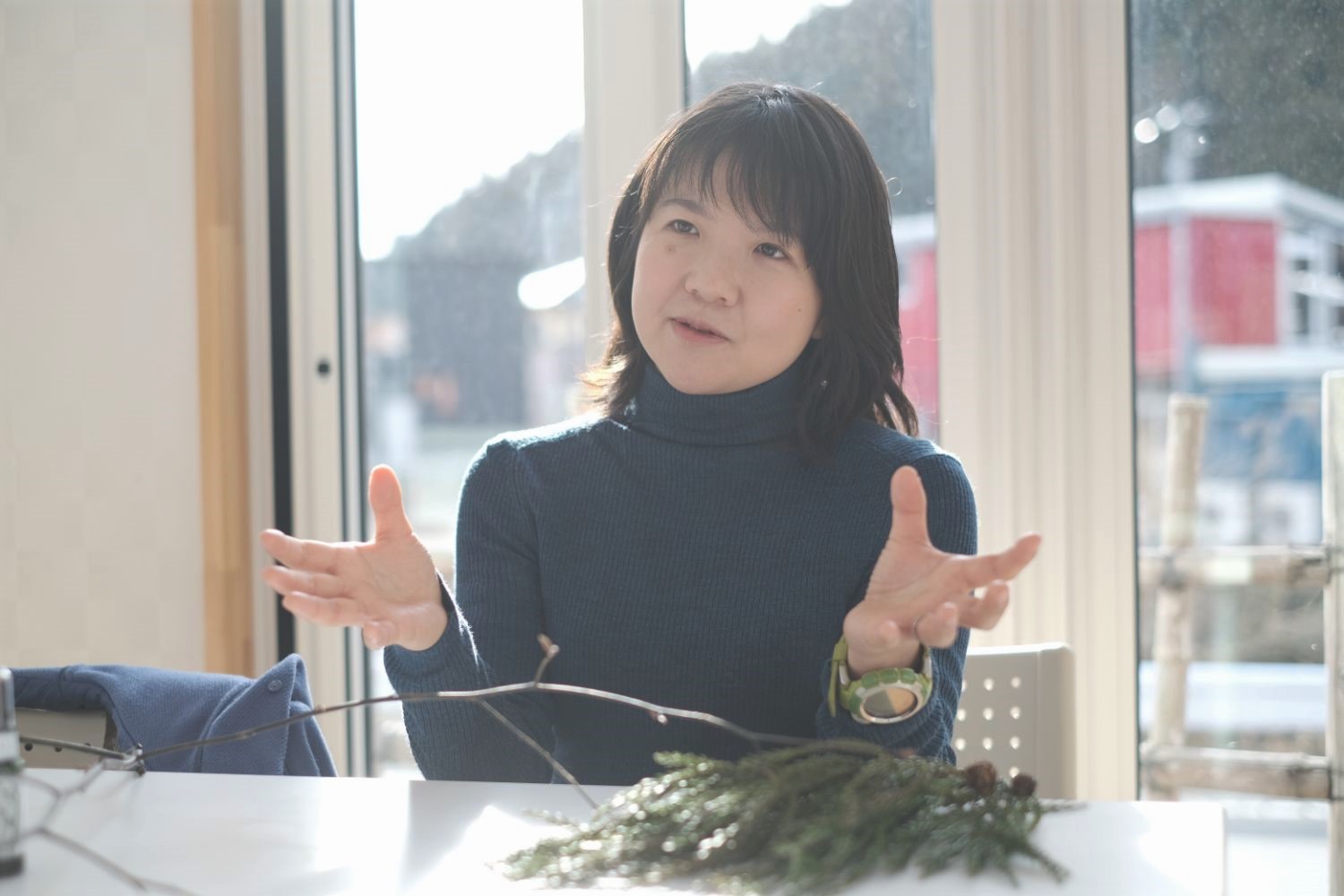 テーブルの上にはクロモジの枝と杉の葉が置かれており、熱心に語っている大渕さんの写真