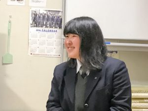 ホワイトボードの前で、笑顔で横を向いている遠藤みすずさんの写真