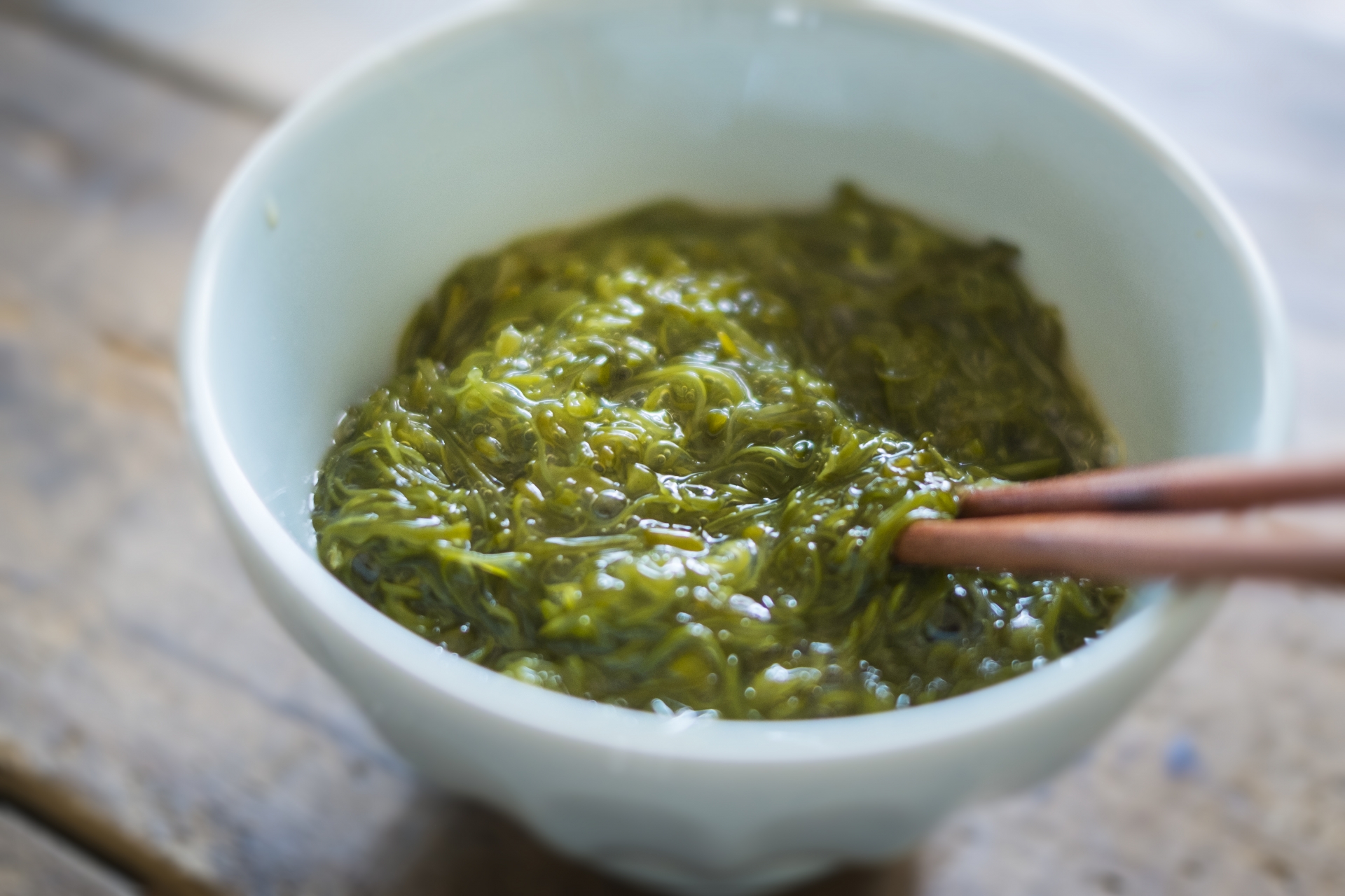 白い陶器の器に緑色のメカブが入っている写真