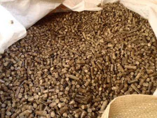 大きな白い袋の中に、細かく成形された円柱状の茶色い木質ペレットがぎっしりと詰められている様子が写っている写真